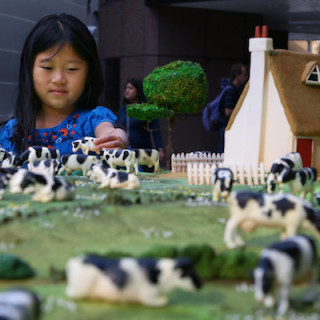 EDITORIAL USE ONLY Mikyla Wibowo, daughter of Food artist Michelle Wibowo plays with the Kerrygold 10-metre squared meadow cake at Finsbury Avenue Square in London. PRESS ASSOCIATION Photo. Picture date: Wednesday July 22, 2015. The cake has been created by Kerrygold to celebrate the butter brandís new campaign, The Tales From The Meadow, following research that revealed four in ten British adults have never been to a countryside meadow. Photo credit should read: Geoff Caddick/PA Wire